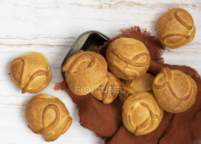 Baked round buns on brown napkin on wooden table — Stock Photo