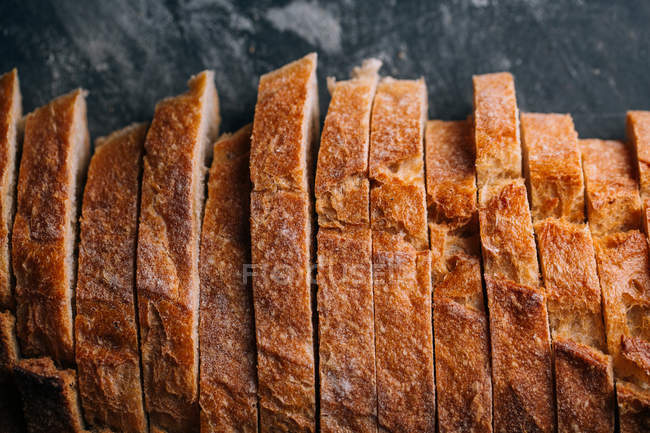 Fette di pane rustico fatto in casa su sfondo scuro — Foto stock