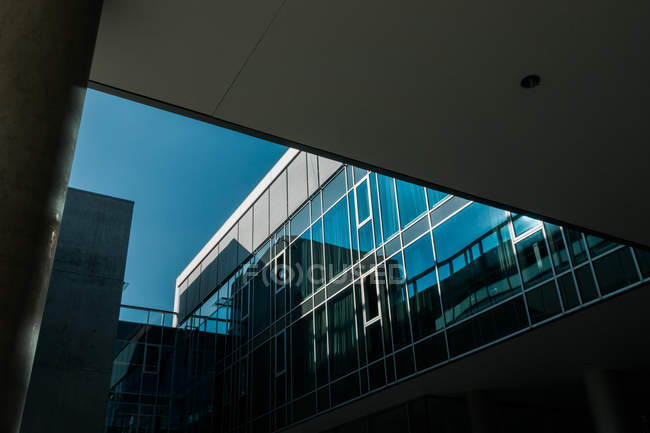 Dunkle Fenster moderner Bauweise gegen blauen Himmel — Stockfoto