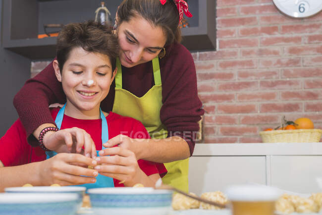 Brothers working with dough and decorating pastry at home — Stock Photo