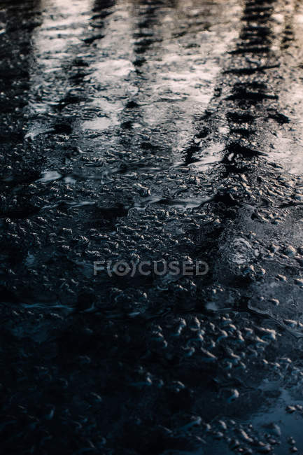 Nahaufnahme von Wasserkügelchen auf dunkler, sauberer Oberfläche — Stockfoto