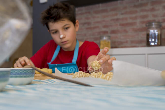 Alegre adolescente concentrado trabajando con pastelería - foto de stock