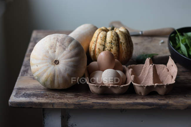 Различные ингредиенты для вкусной тыквы и фриттаты шпината на деревянном столе — стоковое фото