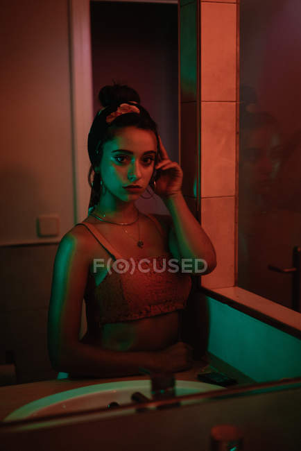 Reflection of passionate attractive brunette woman with hairdo near sink — Stock Photo