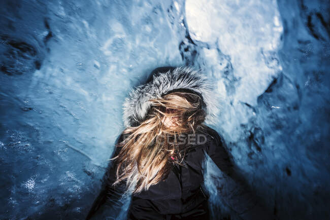 La donna è all'interno di una grotta di ghiaccio e scatta una fotografia a lunga esposizione. — Foto stock