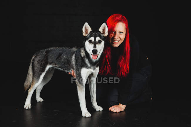 Portrait Of Young Woman With Bright Red Hair With Puppy Of Siberian Husky On Black Background Excited People Stock Photo 237452592