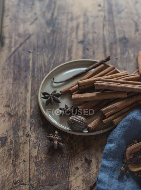 Plate with assorted spices on rustic wooden table — Stock Photo