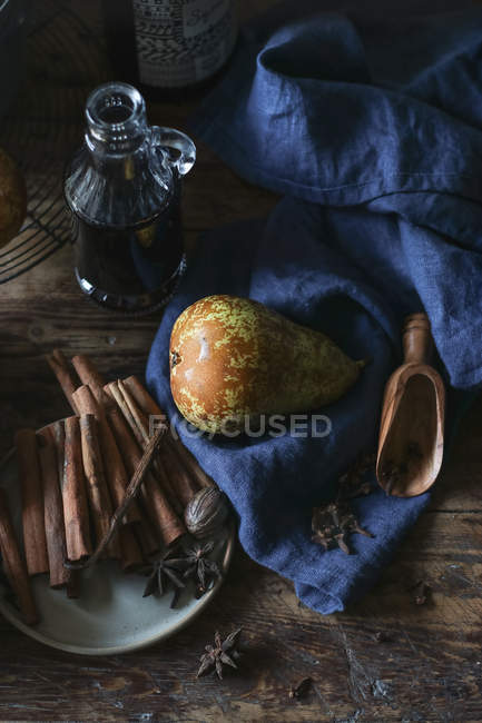 Pear and spices on blue towel near bottle of wine — Fotografia de Stock