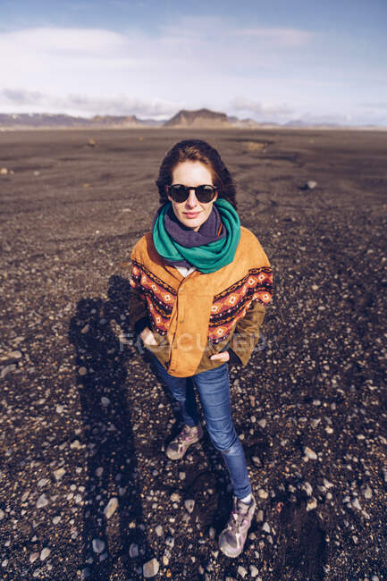Smiling human with standing between dark grounds in Iceland — Stock Photo