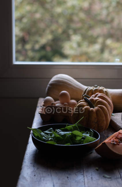 Различные ингредиенты для вкусной тыквы и фриттаты шпината на деревянном столе — стоковое фото