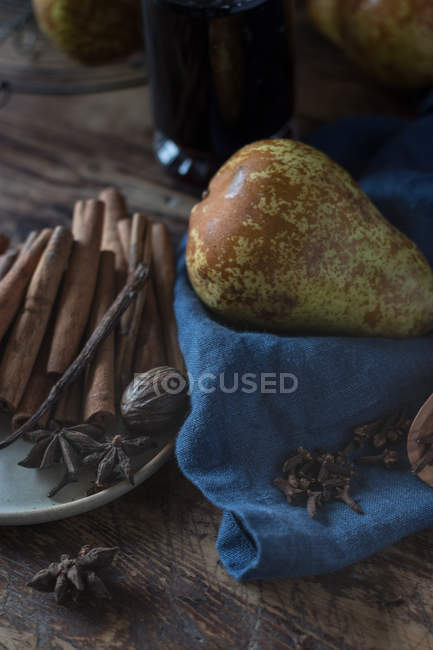 Pear and spices on blue towel near bottle of wine — Stock Photo
