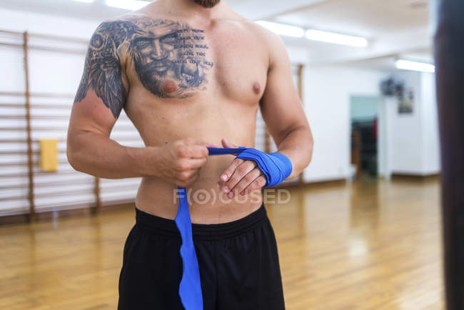 Крупным планом обёртывания рук боксера перед тренировкой в тренажерном зале — стоковое фото