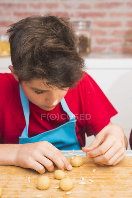 Веселий підліток сконцентрований на роботі з випічкою — стокове фото