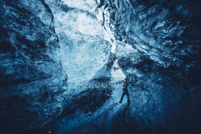 Vue du voyageur marchant dans la fissure d'une belle grotte de glace bleue cristalline, Islande — Photo de stock