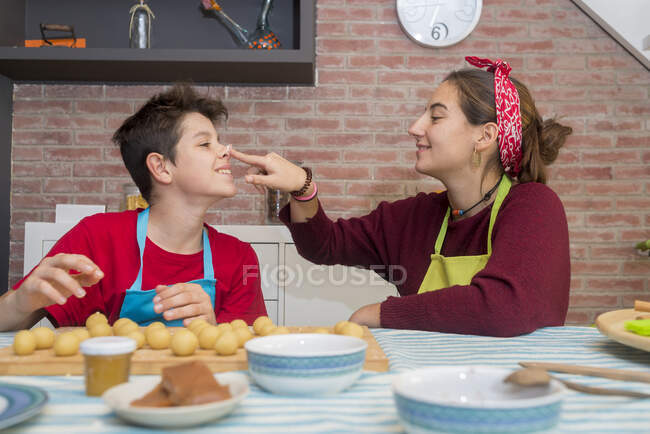 Irmãos brincando com massa e farinha enquanto trabalham em pastelaria em casa — Fotografia de Stock