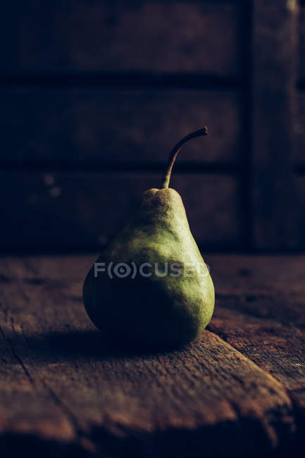 Juicy and ripe pear on dark wooden background — Stock Photo