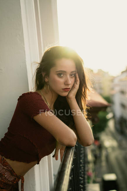 Portrait of bored charming young brunette lady posing on balcony — Stock Photo