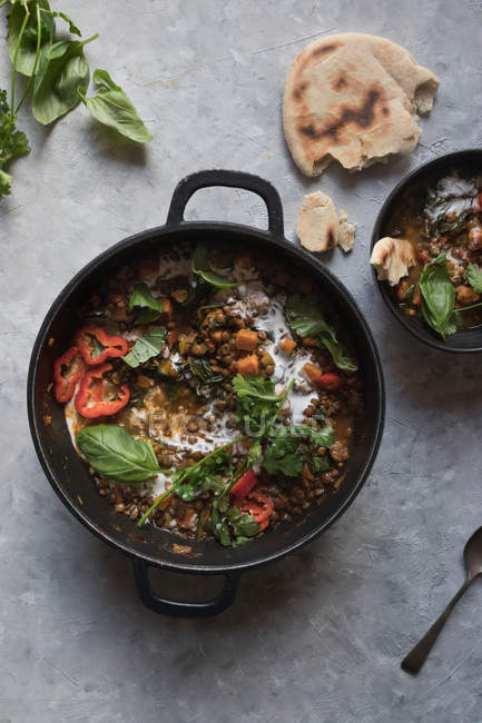 Casserole de ragout avec lentille et curry de patates douces et bol sur plateau gris — Photo de stock