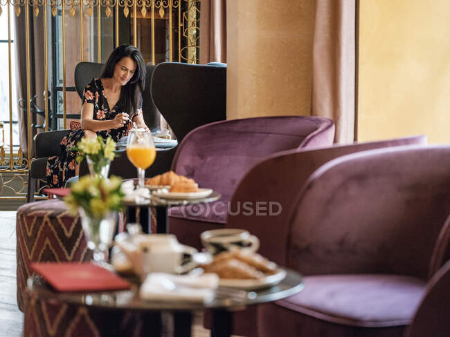 Femme prenant le petit déjeuner dans une chambre de luxe — Photo de stock