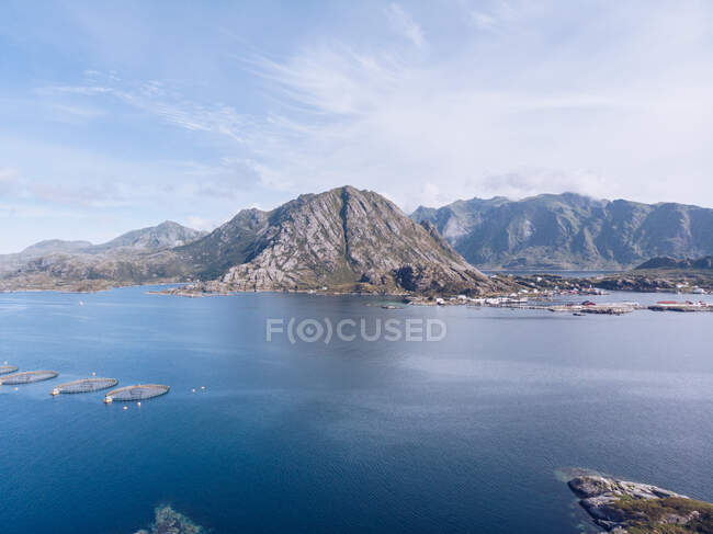 Aerial shot of rocky mountains on coast of blue ocean of Lofoten Islands in bright sunlight, Norway — Stock Photo