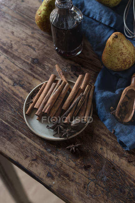 Стиглі груші та спеції на синьому рушнику біля пляшки вина — стокове фото