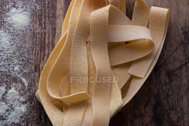 Купка неварених спагеті з папарделлю на дерев'яному столі — стокове фото