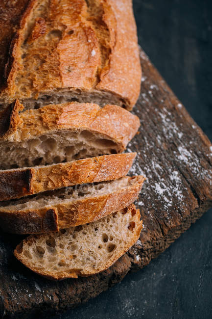 Частково нарізаний домашній сільський хліб на дерев'яній дошці — стокове фото