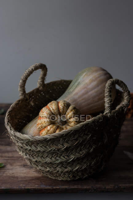 Panier en osier rustique avec citrouilles d'automne — Photo de stock