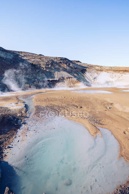 De cima montanha marrom com cratera entre terrenos escuros silenciosos e céu bonito azul na Islândia — Fotografia de Stock