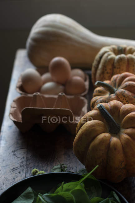 Divers ingrédients pour de délicieuses frittata à la citrouille et aux épinards sur table en bois — Photo de stock