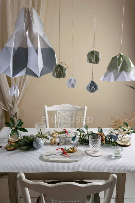 Holiday celebration table setting, in white and gold colors, with hanging decorations decorating the table — Stock Photo
