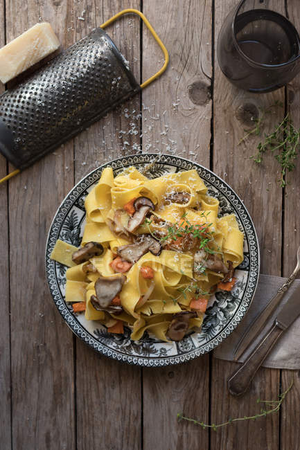 Тарелка приготовленных спагетти с тыквой и колбасой на деревянном столе — стоковое фото