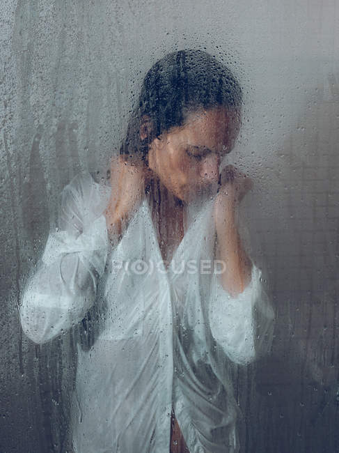 Sopping donna in camicia posa in cabina doccia — Foto stock