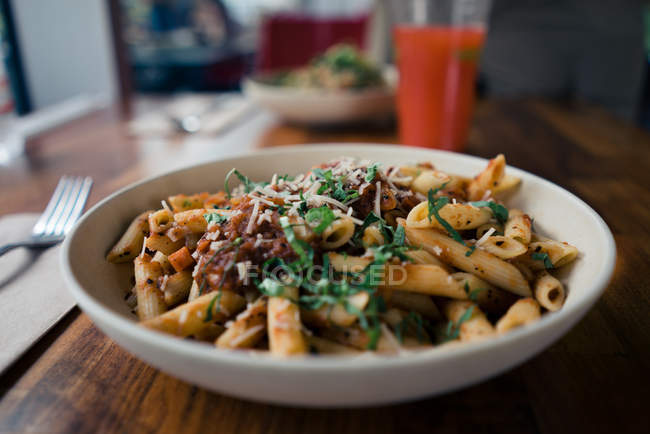 Makkaroni Bolognese und Fleischsoße mit Tomaten und Käse im Teller auf Holztisch — Stockfoto