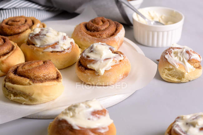 Plate with yummy cinnamon buns with vanilla cream. — Stock Photo