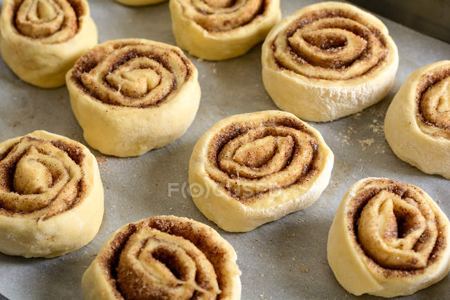 Close-up of small uncooked buns on baking pan. — Stock Photo