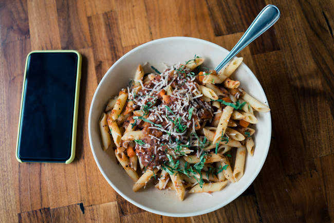 Macaroni bolognaise et sauce à la viande avec tomate et fromage dans une assiette sur une table en bois — Photo de stock