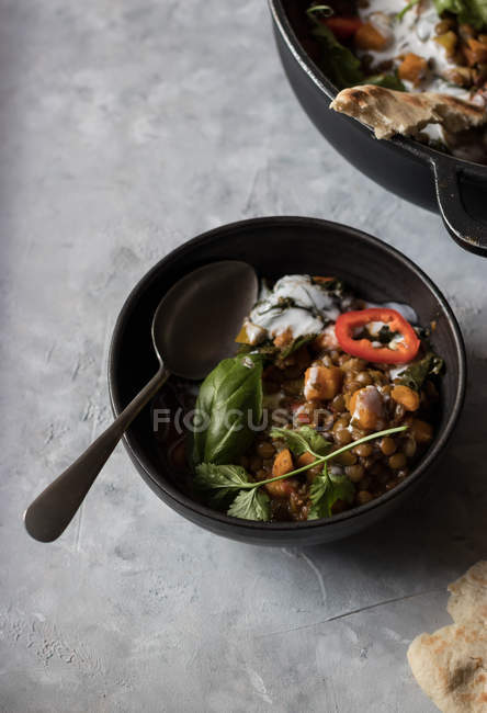Tigela de ragu com lentilha e caril de batata-doce em mesa cinza — Fotografia de Stock
