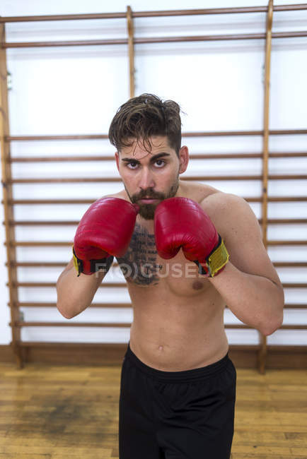 Jeune homme confiant boxe en salle de gym — Photo de stock