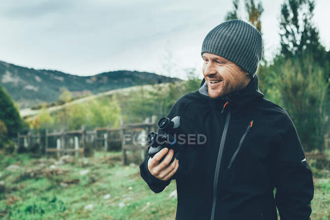 Um jovem caucasiano com binóculos na montanha te em cores de outono — Fotografia de Stock