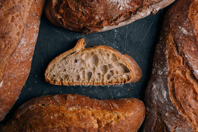 Домашний рустик хлеба хлеба с ломтиком на темном фоне — стоковое фото