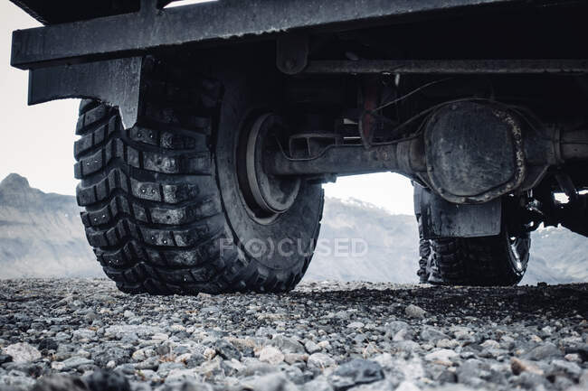 Vista de rodas grandes maciças de caminhão off road na estrada remota rochosa, Islândia — Fotografia de Stock
