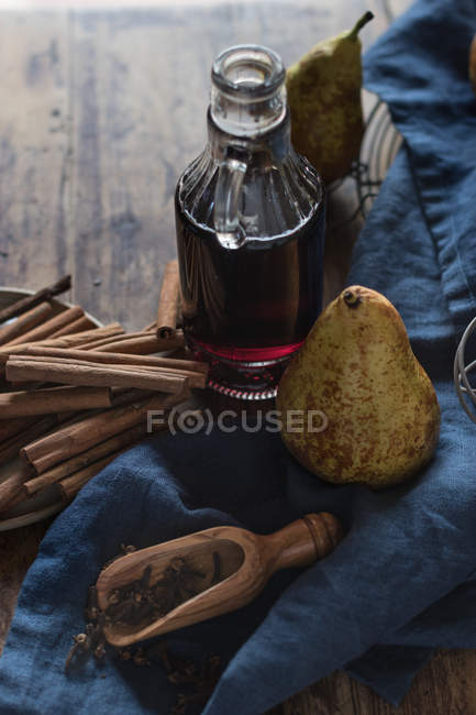Frische Birnen neben Gewürzen und Wein auf blauer Serviette auf Holztisch — Stockfoto