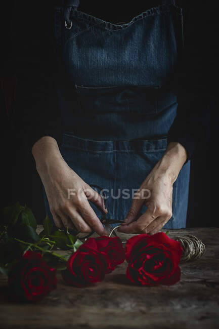 Mulher irreconhecível fazendo um buquê de rosas vermelhas para o Dia dos Namorados. Amor. — Fotografia de Stock