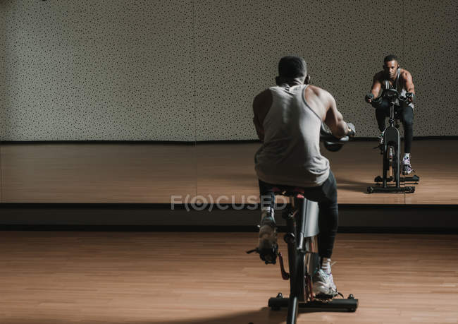 Preto cara fazendo selfie no exercício bicicleta no ginásio — Fotografia de Stock