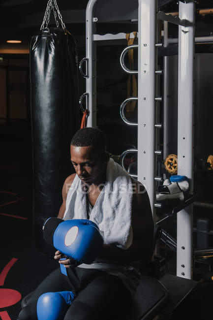 Hombre negro poniéndose guantes de boxeo - foto de stock