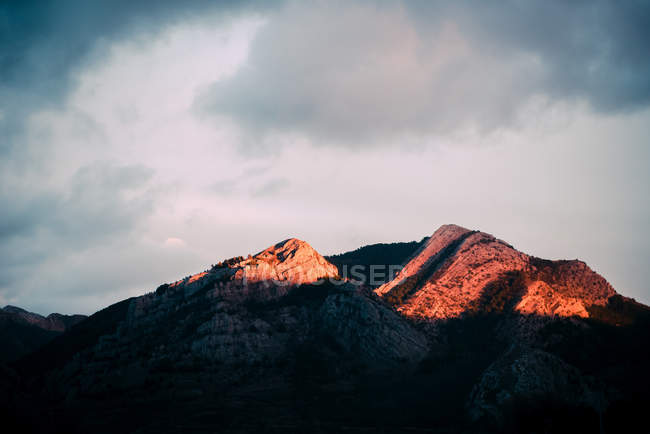 Cielo nuvoloso sopra la cresta della montagna al tramonto — Foto stock