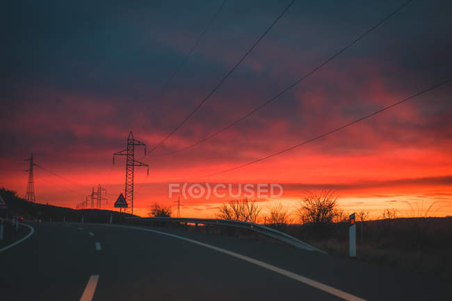 Campagne autoroute route pendant le coucher du soleil avec ciel dramatique — Photo de stock