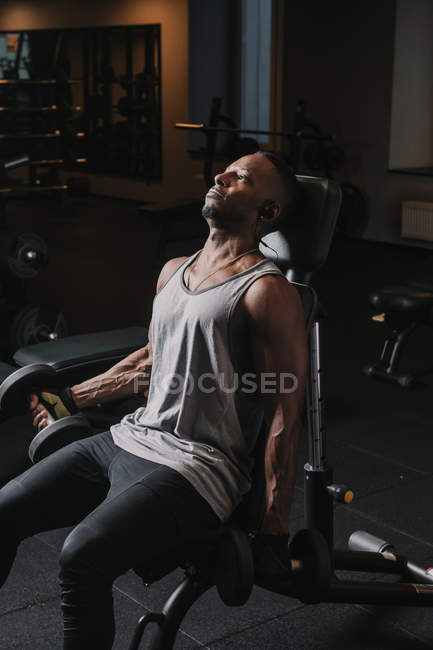 Noir guy exercice avec haltères dans salle de gym — Photo de stock
