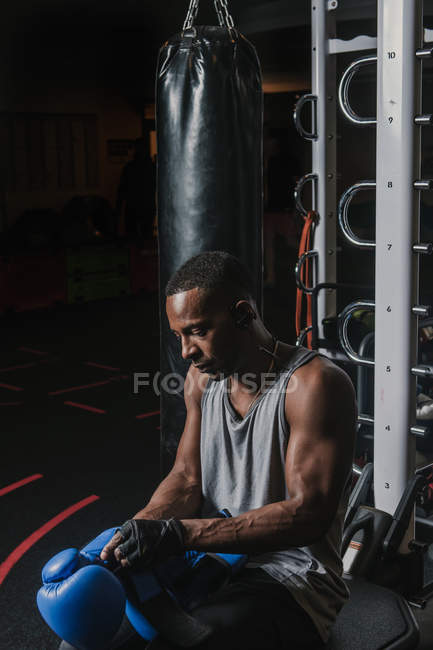 Hombre negro poniéndose guantes de boxeo - foto de stock